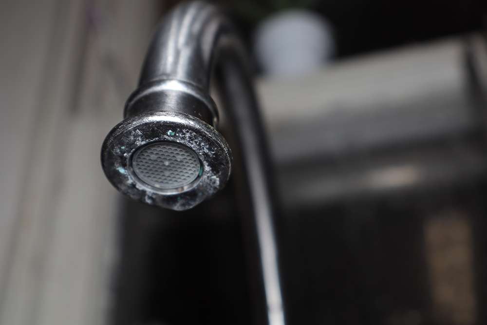 A modern water fixture with hard water build-up